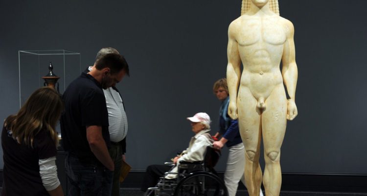 Visitors look at a Marble statue of a Kouros, representing the Greek physical ideal during the Archaic period (700-480 BC), at the Getty Villa Museum in Malibu, California on April 18, 2011. The Getty Villa exhibits classical antiquities collection of Greek, Roman and Etruscan art. The Villa is modeled after a Roman country house buried by the eruption of Mt. Vesuvius in 79 AD. AFP PHOTO / GABRIEL BOUYS (Photo credit should read GABRIEL BOUYS/AFP/Getty Images)
