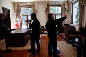 Visitors take photos inside the presidential office at the presidential residence know as Los Pinos in Mexico City, Saturday, Dec. 1, 2018. Inside the compound, successive presidents had built several homes, ranging from palatial to casual. There are unmistakeable signs of luxury: there was marble, art works on the walls, room-sized closets and wood-paneled libraries and offices. There was a small cinema in the basement of one building. (AP Photo/Ginnette Riquelme)